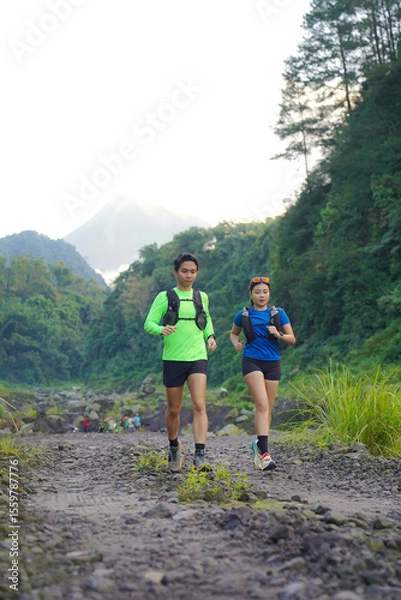 Obraz Asian Indonesian couple trail running near Merapi volcano, active sport and sustainable lifestyle