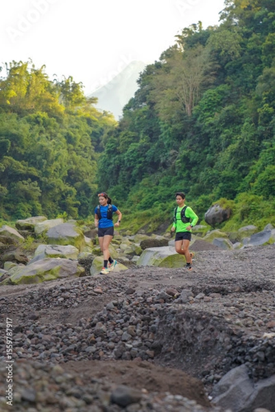 Obraz Asian Indonesian couple trail running near Merapi volcano, active sport and sustainable lifestyle