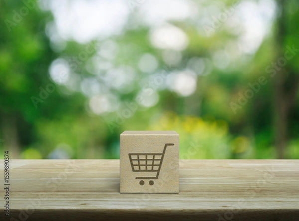 Fototapeta Shop cart flat icon on wood block cube on wooden table over blur green tree in park, Business shopping online concept