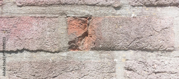 Fototapeta Chip inside a brick on a Weathered brick wall showing different textures. Close-up