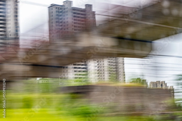 Obraz Dynamic motion blur view from high-speed train window: Green landscape, trees & fields rush past at high speed