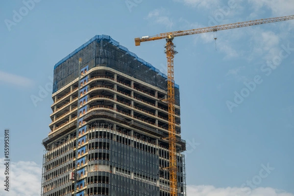 Obraz tall building under construction with crane in Chongqing, China