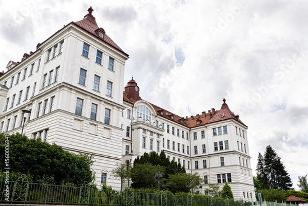 Fototapeta Historic rectorate of Brno University of Technology, white Neo-Renaissance façade with red mansard roofs against cloudy sky 