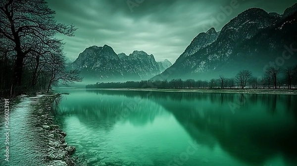 Fototapeta Serene reflection of majestic mountains in a tranquil lake under a cloudy sky