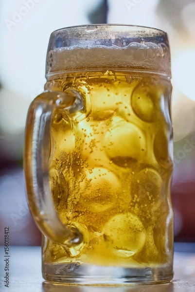 Fototapeta a pint of cold and steaming beer on a table