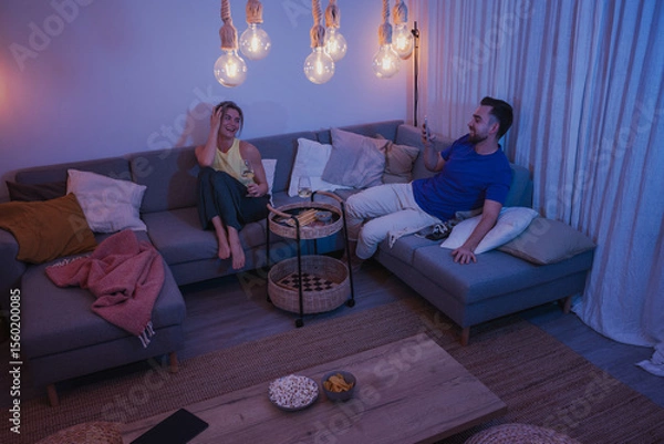 Obraz Man Taking Photo of Girlfriend During Cozy Evening with Wine and Snacks