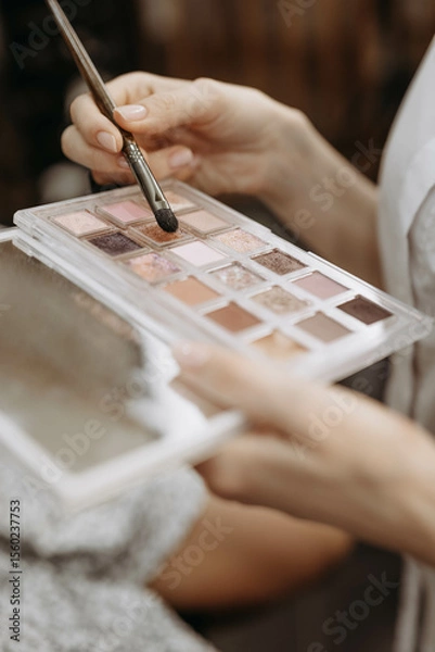 Fototapeta Make-up artist at work. Make-up artist tools: brush and palette for make-up in the hands of a specialist. Vertical view and close-up