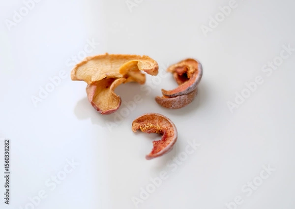 Fototapeta Several pieces of dry fruits on a white background. Healthy preserves dried fruits. A pile of dried fruit. Top view