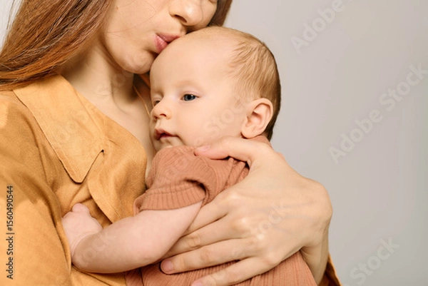 Fototapeta Joyful moments of a beautiful young mother embracing her little child in a warm, intimate setting