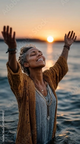 Obraz A devotee standing alone in water with eyes closed hands raised during sunrise