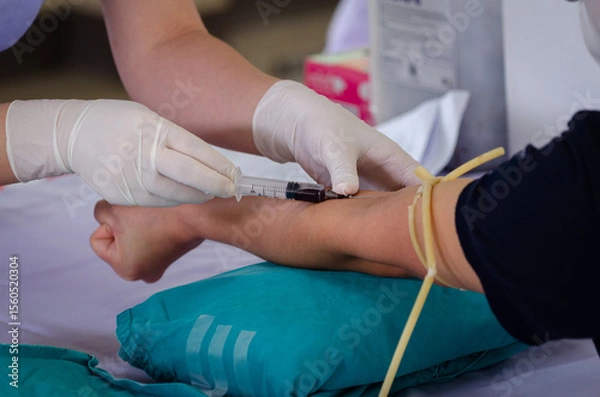 Obraz Close up nurse pricking needle syringe in the arm patient drawing blood sample for blood test , Health check