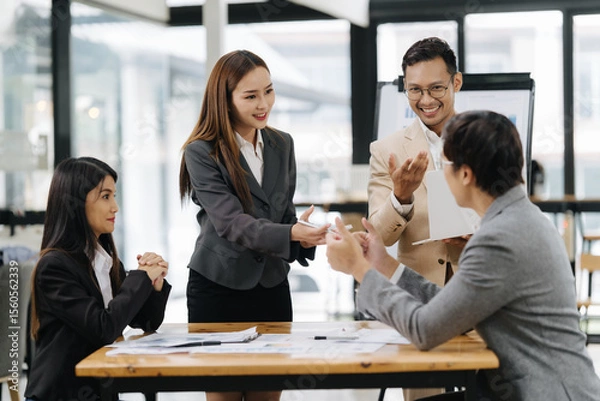 Fototapeta Business Meeting Dynamics: In a contemporary workspace, business professionals engage in a focused meeting, exchanging ideas and fostering collaboration.