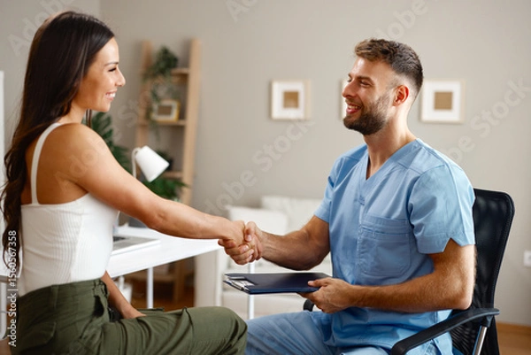 Obraz Doctor shaking hands with patient after successful medical examination