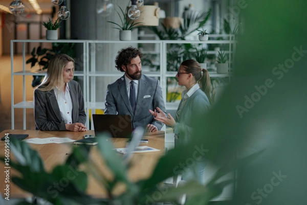 Fototapeta Business team discussing strategy in modern green office
