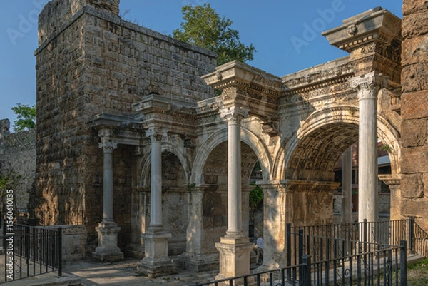 Fototapeta The Arch of ancient times. The famous gate, built in honor of the ancient Roman emperor. The Arc de Triomphe in the Kaleici area. Hadrian's Gate in Antalya. The arch is decorated with carved patterns.