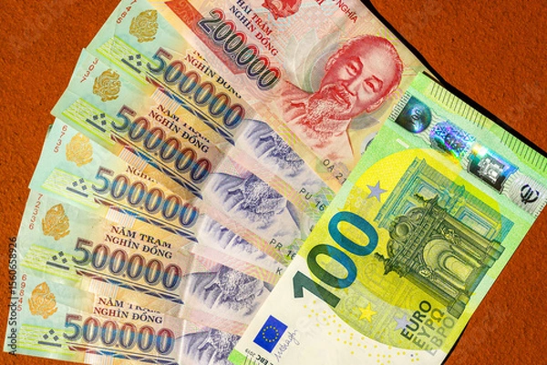 Fototapeta Equivalence of Vietnamese dong and Euro banknotes displayed together on a textured orange background