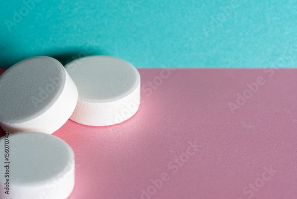 Obraz Three white medicine tablets laying unordered isolated on pink and blue pastel background as macro 3