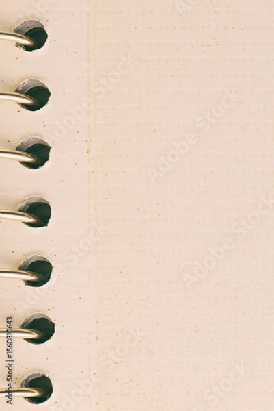 Fototapeta A close-up view of a spiral bound notebook showcasing its beige textured paper