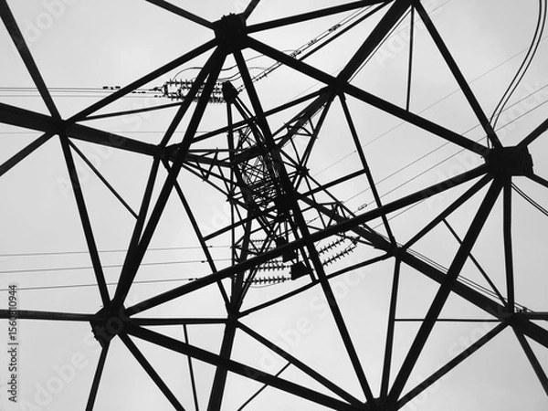 Fototapeta Architectural web of high voltage power lines against overcast skyline clouds