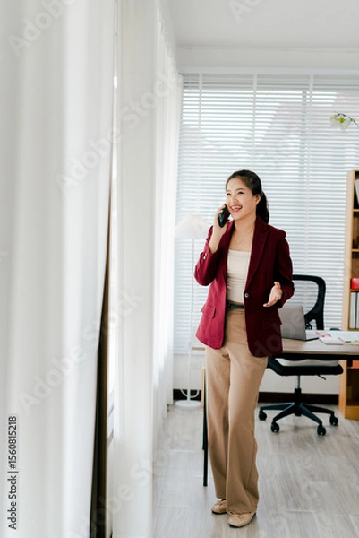 Fototapeta Asian businesswoman chatting on smartphone, auditor, document search, report, analysis, tax, accounting, document, data, contract, agreement at work.