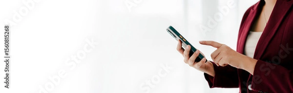 Fototapeta Portrait of young woman holding smartphone, typing text, chatting with friends on social network. Concept of using mobile application, online shopping, opening website, ordering food, business.