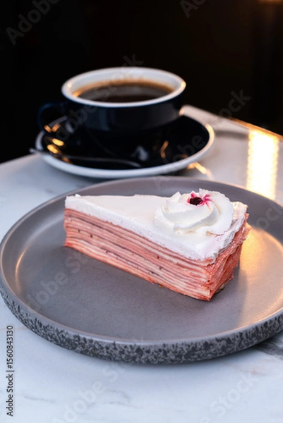 Fototapeta Strawberry Crepe Cake Slice with Cream Topping and Coffee on Marble Table