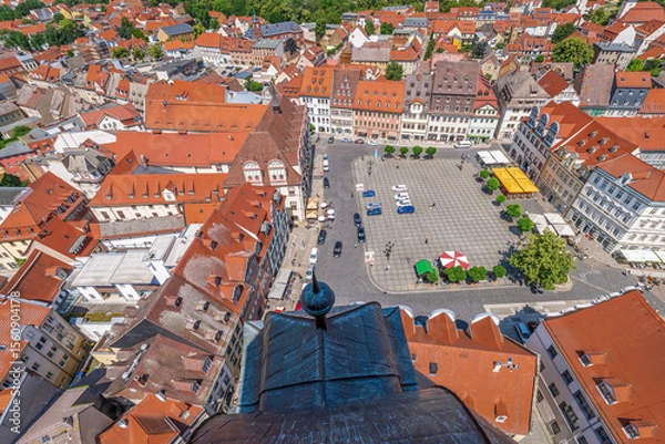Obraz Aerial view of a picturesque European market square with historic buildings, red tiled roofs, trees, and cozy outdoor seating