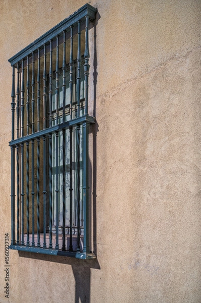 Obraz Old Teal Wrought Iron Window Bars on a Faded Yellow Wall.