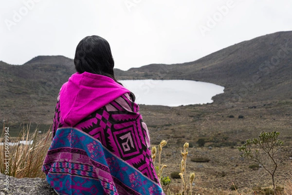 Fototapeta woman sitting on a viewpoint into colombian sumapaz paramo with clkoudy sky at background