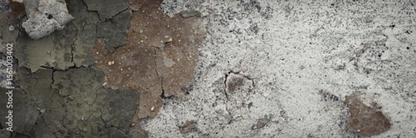 Fototapeta Peeling paint on the wall. Panorama of a concrete wall with old cracked flaking paint. Weathered rough painted surface with patterns of cracks and peeling. Wide panoramic grungy texture for background