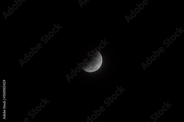 Fototapeta full moon during a partial phase of an eclipse with mist and black background