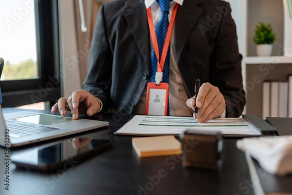 Obraz a businessman is reviewing accounting and financial statistics documents in his private office, the statistician prepares various charts and documents for a meeting