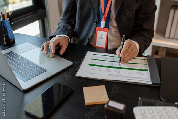 Obraz a businessman is reviewing accounting and financial statistics documents in his private office, the statistician prepares various charts and documents for a meeting