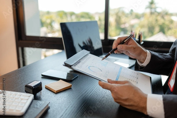 Obraz a businessman is reviewing accounting and financial statistics documents in his private office, the statistician prepares various charts and documents for a meeting