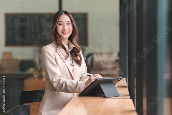 Obraz Professional woman engaging with digital tablet in modern office environment for enhanced productivity and collaboration
