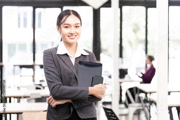 Obraz Portrait of happy businesswoman with touchpad in office looking at camera.