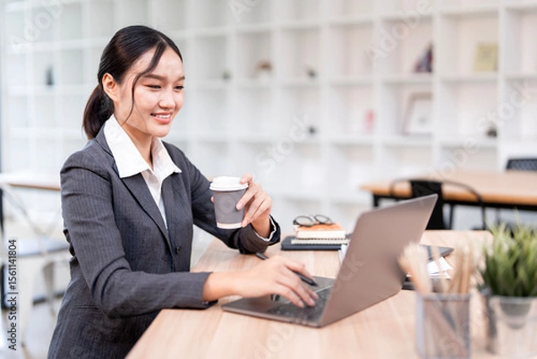 Obraz Portrait of smiling businesswoman sitting at desk in the office
