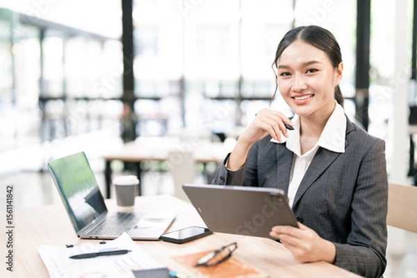 Obraz Portrait of smiling businesswoman sitting at desk in the office