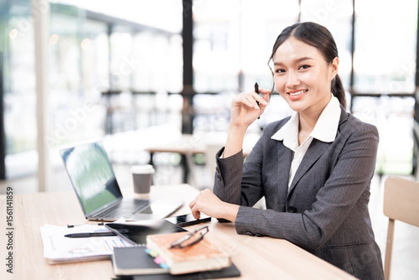 Obraz Portrait of smiling businesswoman sitting at desk in the office