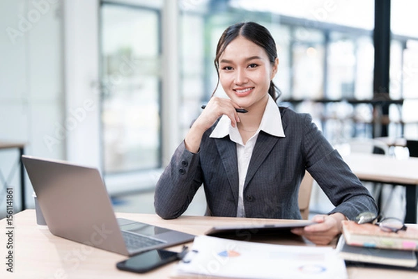 Obraz Portrait of smiling businesswoman sitting at desk in the office