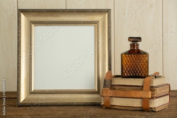 Obraz Photo frame, perfume and book stack on table