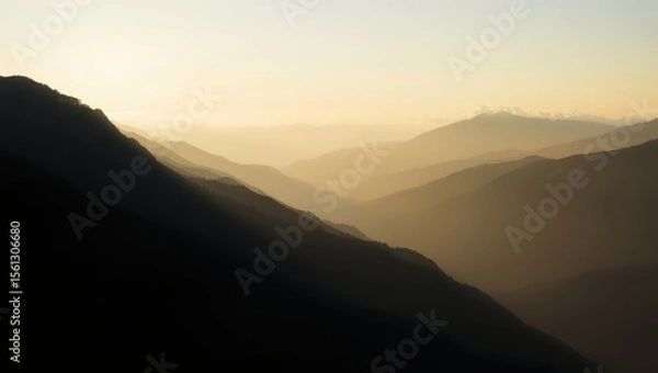 Obraz Minimal wide landscape shot of layered mountain silhouettes during sunrise, with mist covering the valleys and soft light breaking through clouds. Calm, peaceful tone, high-resolution matte texture, n