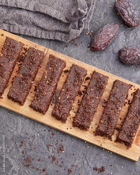 Fototapeta Chocolate date protein bars with amaranth on wooden board