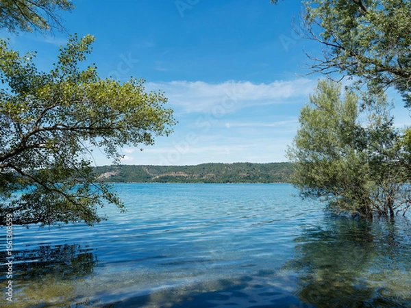 Fototapeta  Les eaux turquoises du lac de Sainte-Croix depuis la rive sud le long du sentier GR 99 depuis Bauduen avec vue sur le pont et Barrage ainsi que les gorges de Bodinard à l'horizon 
