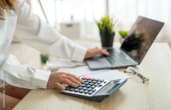 Fototapeta Human use calculator and calculate bills and paying bill, credit card, tax and vat, payment, concept of money management and business report with financial documents, financial accounting concept