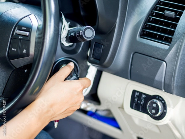 Obraz Hand putting car key to the keyhole, starting the car