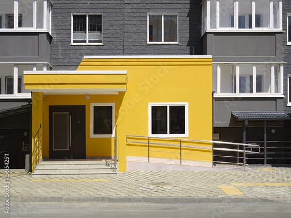 Fototapeta Beautiful modern colored entrance to a residential building and a ramp for wheelchair users.