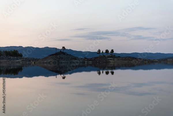Obraz Trees on island reflecting in the water, Tunhovd lake in Norway