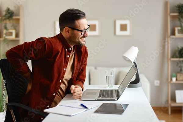 Obraz Freelancer experiencing back pain while working from home