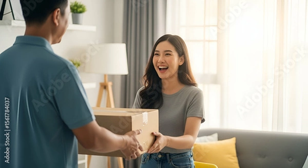 Fototapeta Happy woman receiving package delivery at home with a bright and cozy interior, showcasing joy and surprise in modern living environment